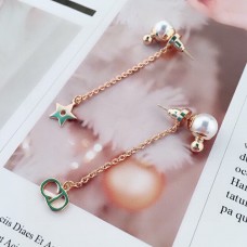 Dior La Petite Tribale CD Signature sterdetail witte parel geelgouden asymmetrische oorbellen